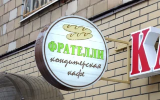 Круглая конструкция на кронштейне на кирпичном фасаде