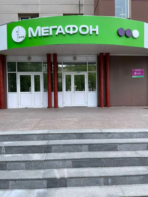 Зелёная угловая вывеска «МегаФон» над входом