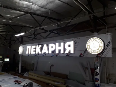 Светящаяся вывеска «Пекарня» на подложке в производственном помещении