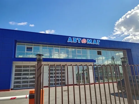 Вывеска «Автомаг» над окнами на синем фасаде