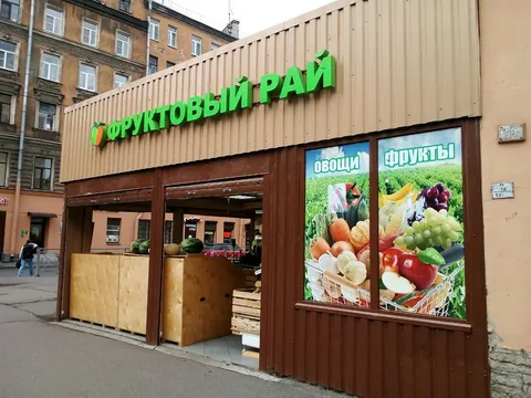 Зелёная вывеска «Продуктовый рай» над входом в магазин