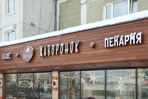 Белые буквы вывески пекарни на деревянной подложке