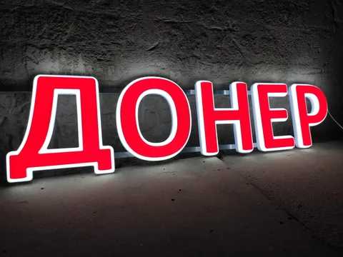 Красные буквы «Донер» со светлым контуром на тёмной стене